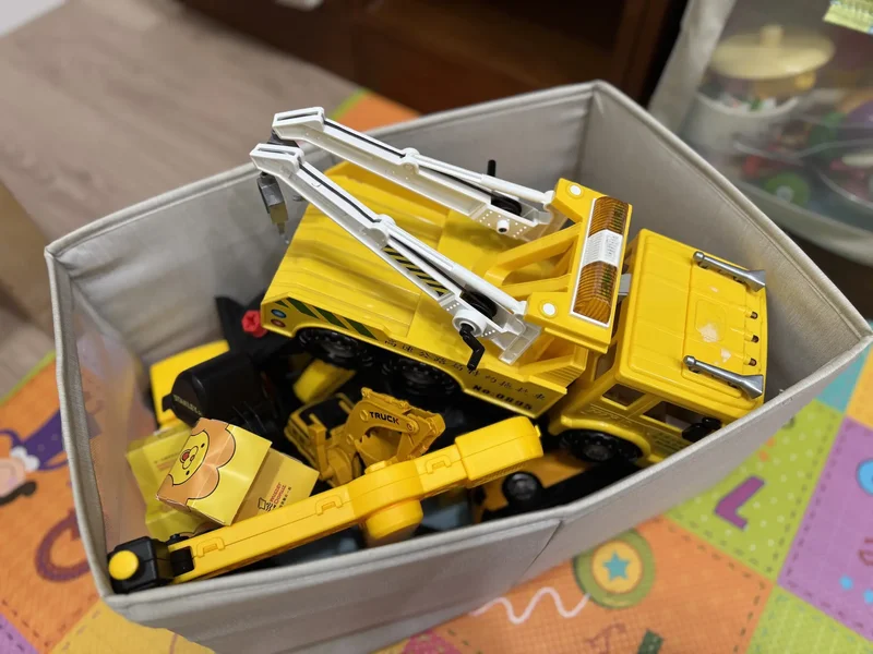 布質收納箱只放大型黃色工程車，依外型與系列分類玩具，孩子一眼就知道車車在哪
